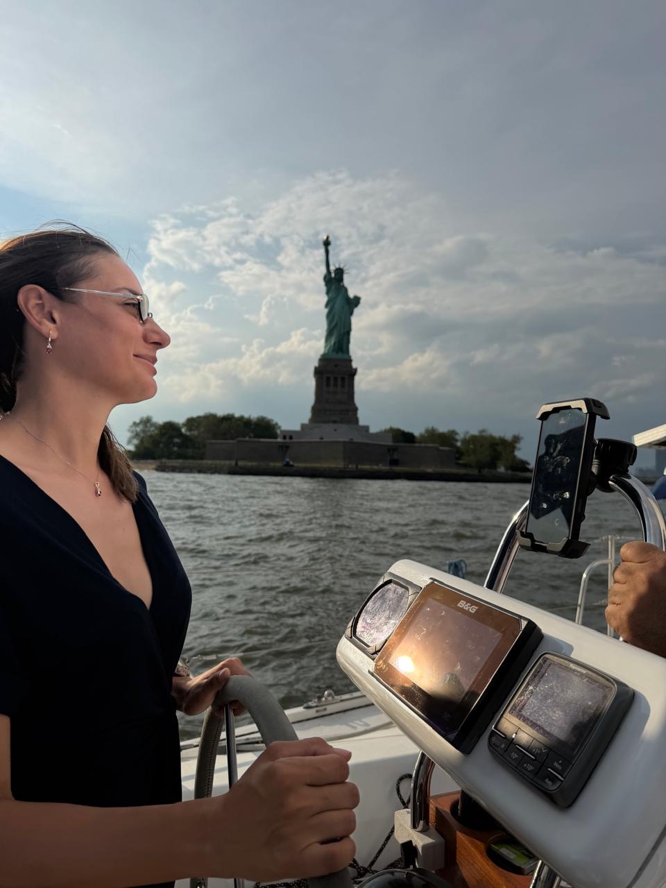 Belemir Dedeoğlu at the helm, the Statue of Liberty is visible in the background