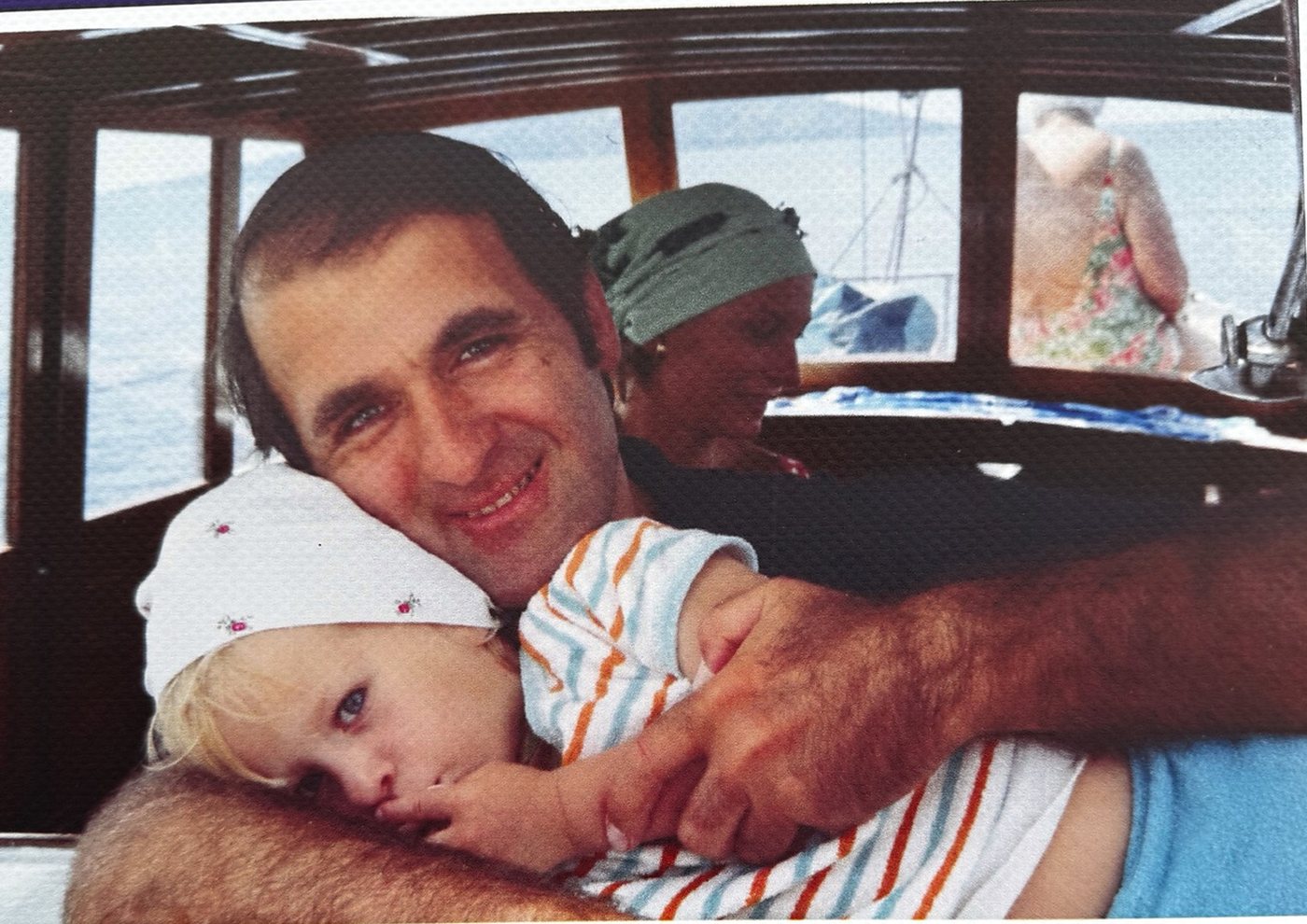 Teknede küçük bir çocuğa sarılan bir baba, arşiv fotoğrafı